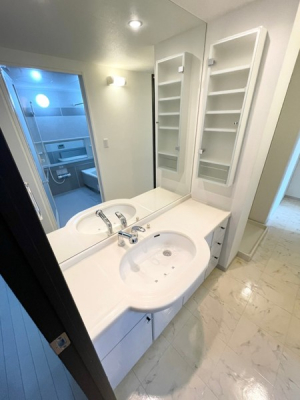 洗面台・洗面所　大型の鏡が特徴的な洗面化粧台横には備え付けの収納付きです。