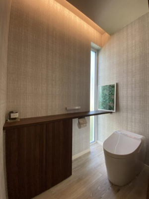 トイレ　収納付きのカウンター・天井の間接照明・自然彩光を取り入れたトイレ、洗練された空間スティックリモコン仕様
